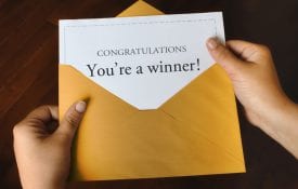 An envelope with a card that says, "congratulations! You're a winner