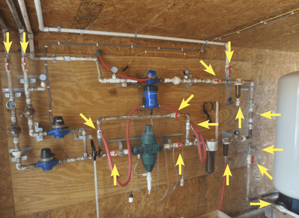 Figure 1. Yellow arrows highlight 15 valves used in this water manifold feeding a 40 x 500 commercial broiler house.