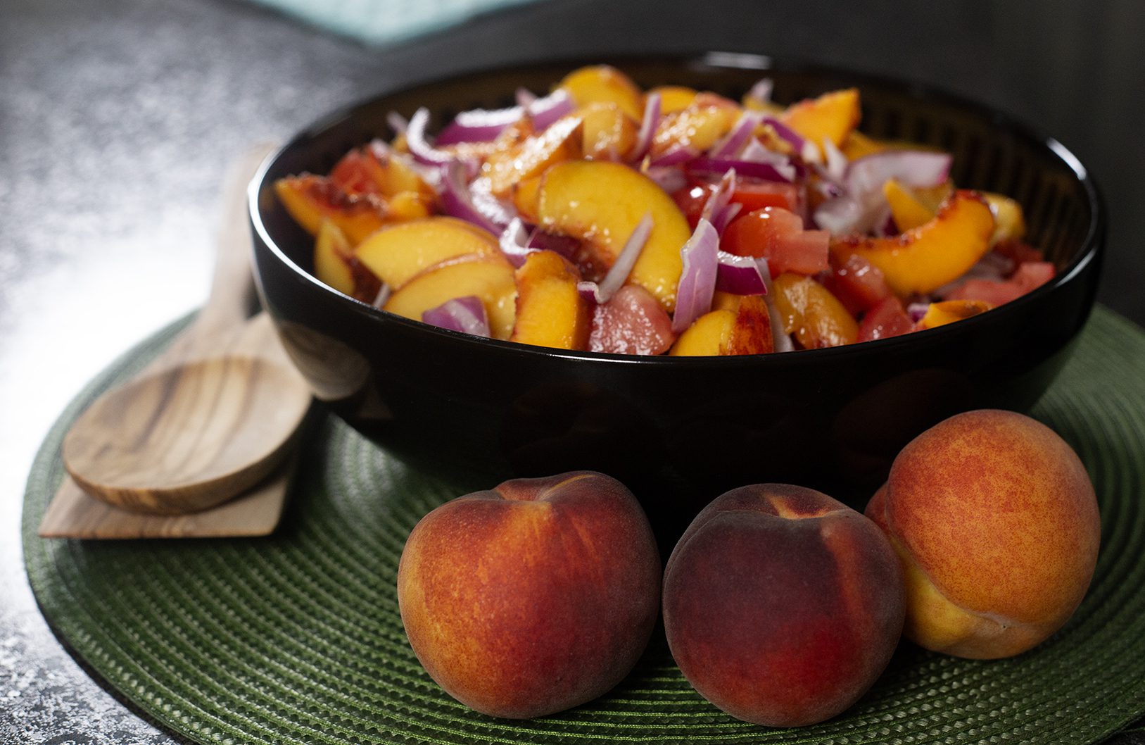 A Farmers Market Salad with peaches, tomatoes, and purple onions.