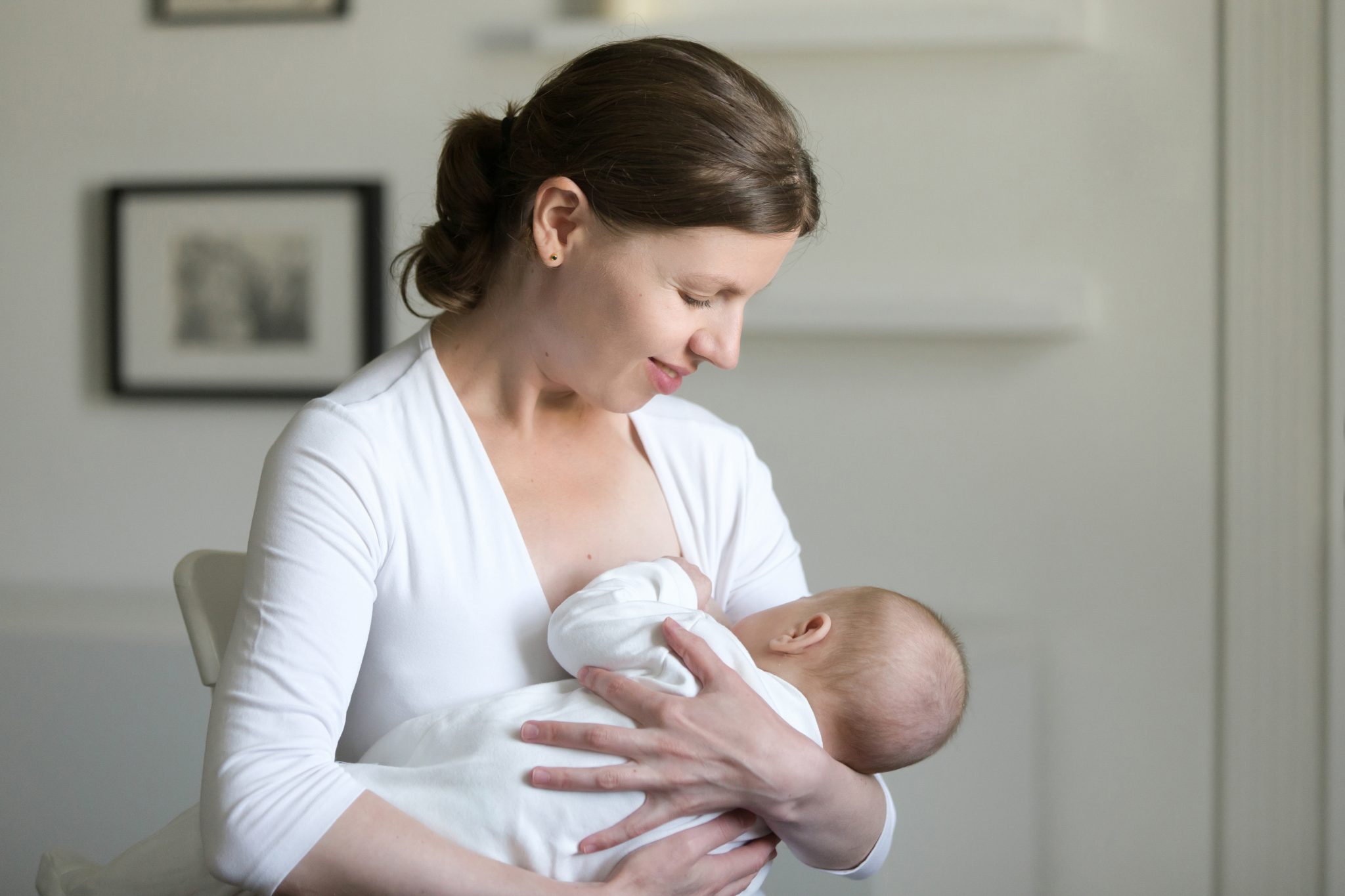Portrait Of A Young Woman Breastfeeding A Child; national breastfeeding month