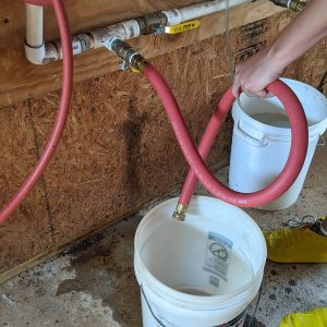 Figure 7. Use a short water hose to ensure all the water is flowing into the 5-gallon bucket.