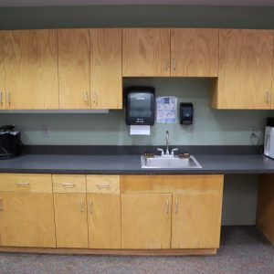 Agribition refreshment center with sink, counter, and coffee maker.