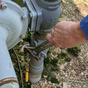 Figure 5. Open the shutoff valve on a propane tank with your hand (top); open the shutoff valve entering the natural gas meter with a wrench (bottom).