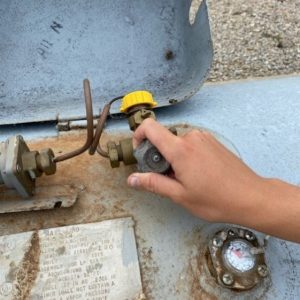 Figure 5. Open the shutoff valve on a propane tank with your hand (top); open the shutoff valve entering the natural gas meter with a wrench (bottom).