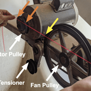 Figure 3. A 3-foot piece of bright nylon construction string is stretched across the face of both the motor pulley and fan pulley. The fan belt has been removed during this check. You want to have four points of contact (shown by orange arrows for the motor pulley and yellow arrows for the fan pulley). Make sure not to lap over any raised areas near the shaft, this will give a false reading.