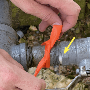 Figure 9. Mark each leak with flagging tape or equivalent and note it on the worksheet. This brass shutoff valve has a small leak near the natural gas meter.