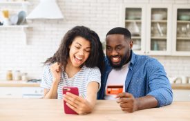 Young black couple buying something with a credit card
