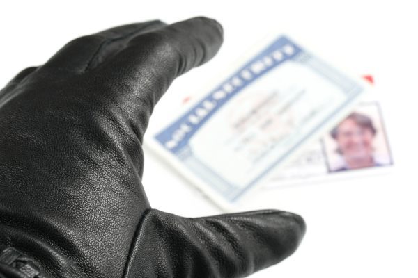 Image of a black glove grabbing a social security card