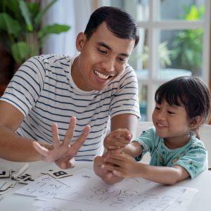 A father and daughter playing at a table