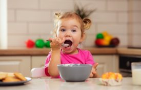 Happy young child eating breakfast