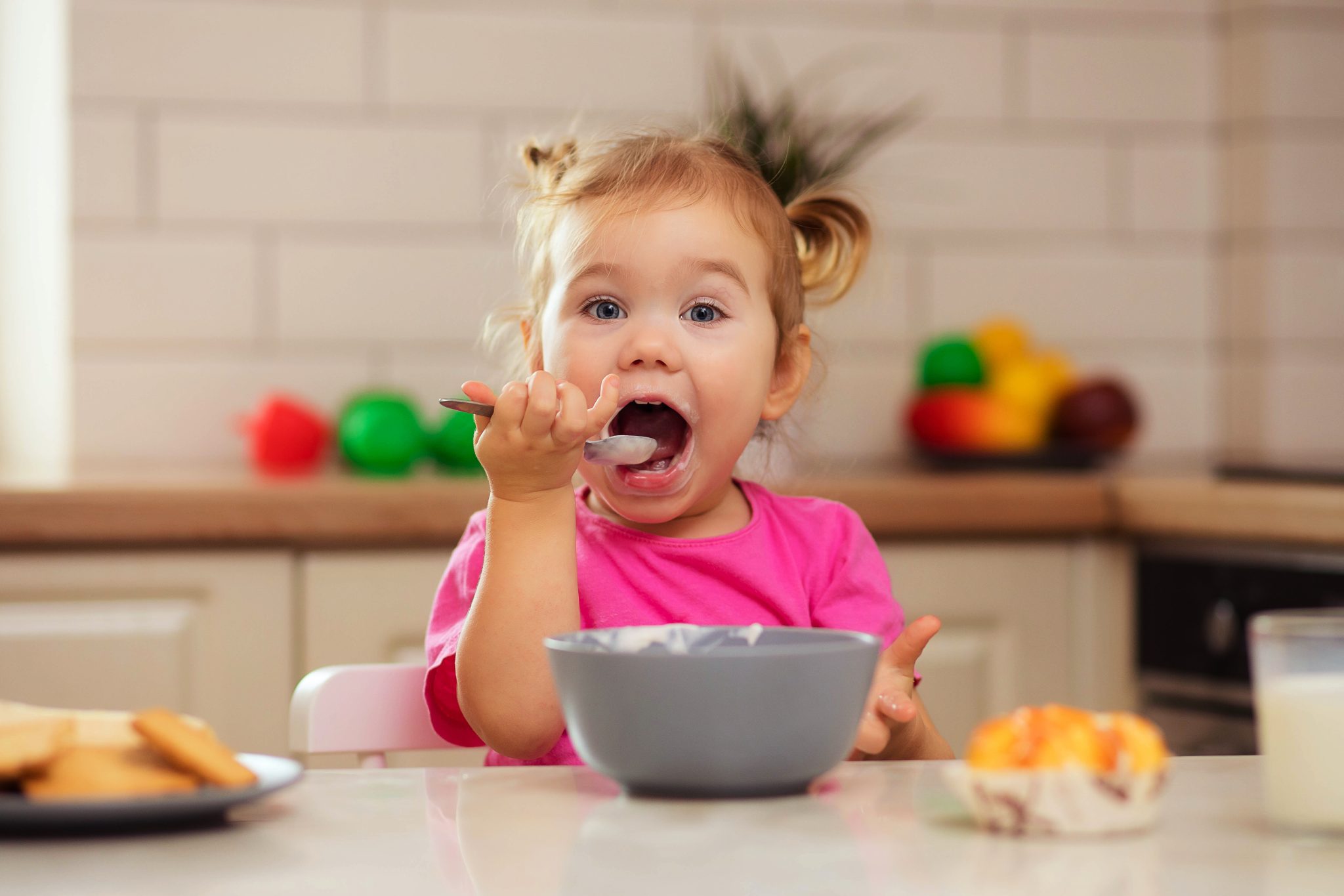 Happy young child eating breakfast