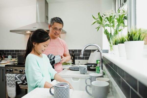 Father and daughter cleaning dishes