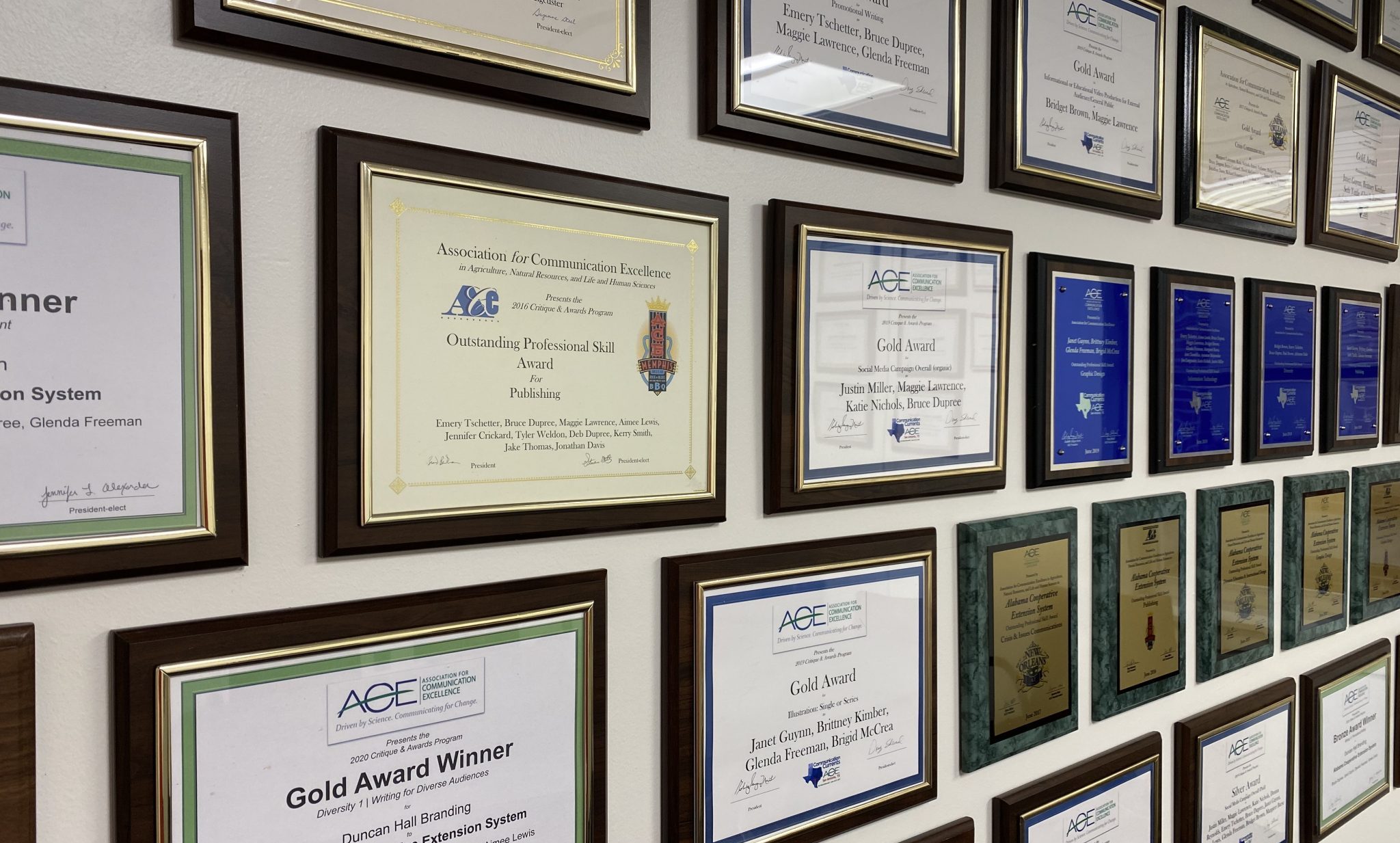 A wall filled with ACE award certificates