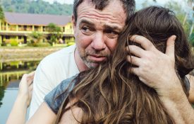 A sad man hugging his daughter