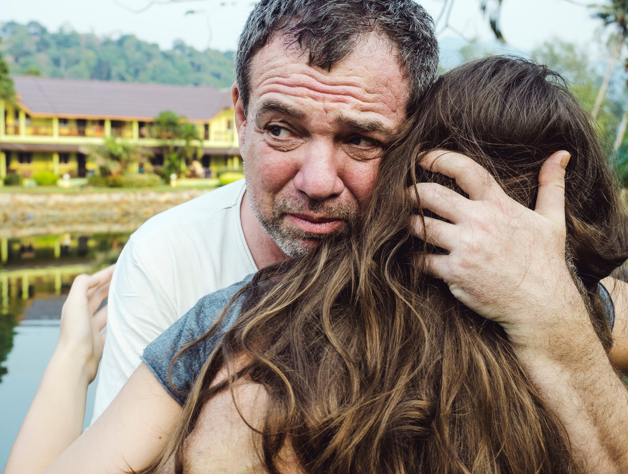 A sad man hugging his daughter