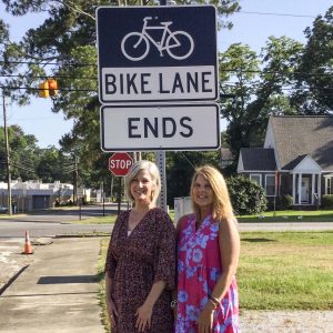 Pam Stenz and Tammy Glass pictured with a newly-installed bike safety sign.