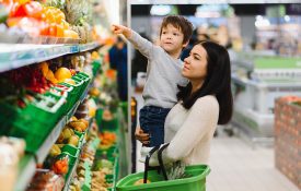 woman, boy, pointing at vegetables in a grocery store