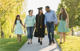 Family holding hands and walking at graduation