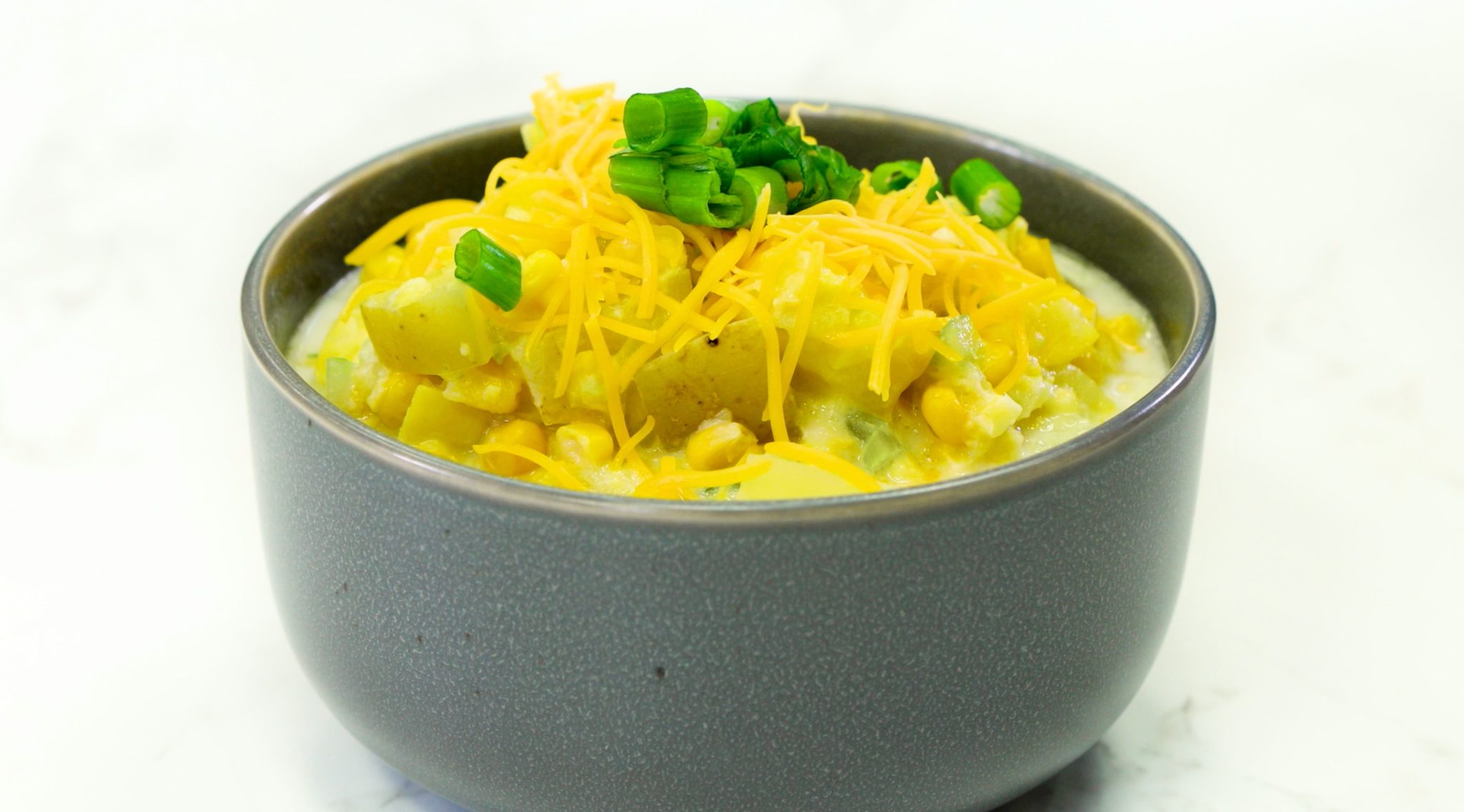 Squash and Corn Chowder, chowder and cheese in grey bowl