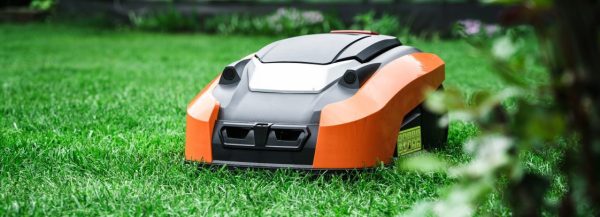 Lawn robot mows the lawn. Robotic Lawn Mower cutting grass in the garden.