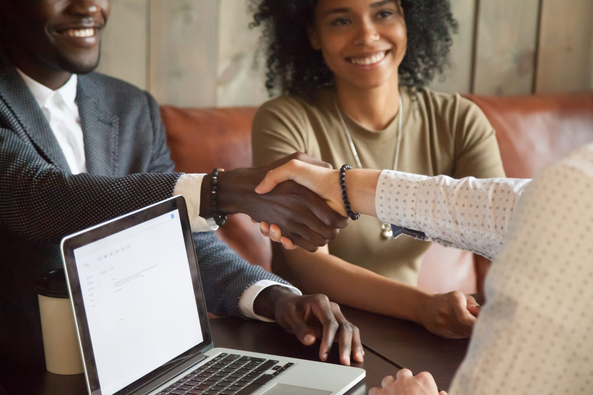 Happy african american couple making deal handshaking with broker, closeup