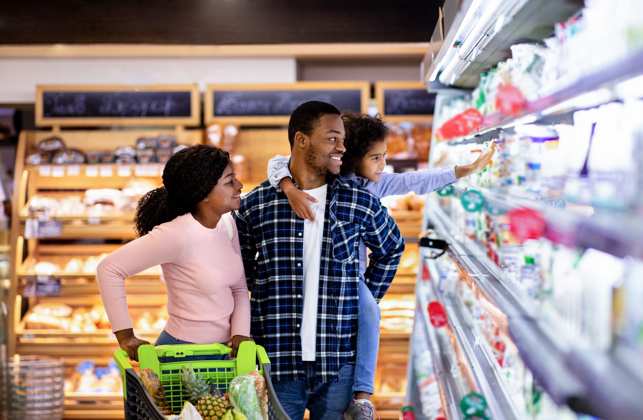 A young black family shopping at the grocery store.