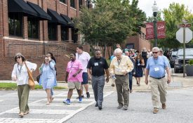 Attendees of the Main Street Alabama Awards and Conference walk downtown in Opelika