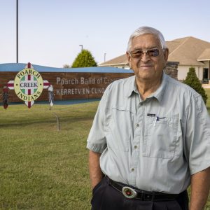 Eddie Tullis posed by the entry sign at the Poarch Band of Creek Indians Museum