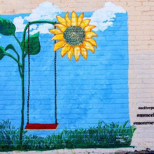 blue mural with swing and yellow flower