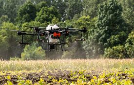 DJI AGRAS drone spraying an agriculture field
