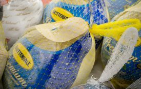 Several frozen turkeys in a grocery store.