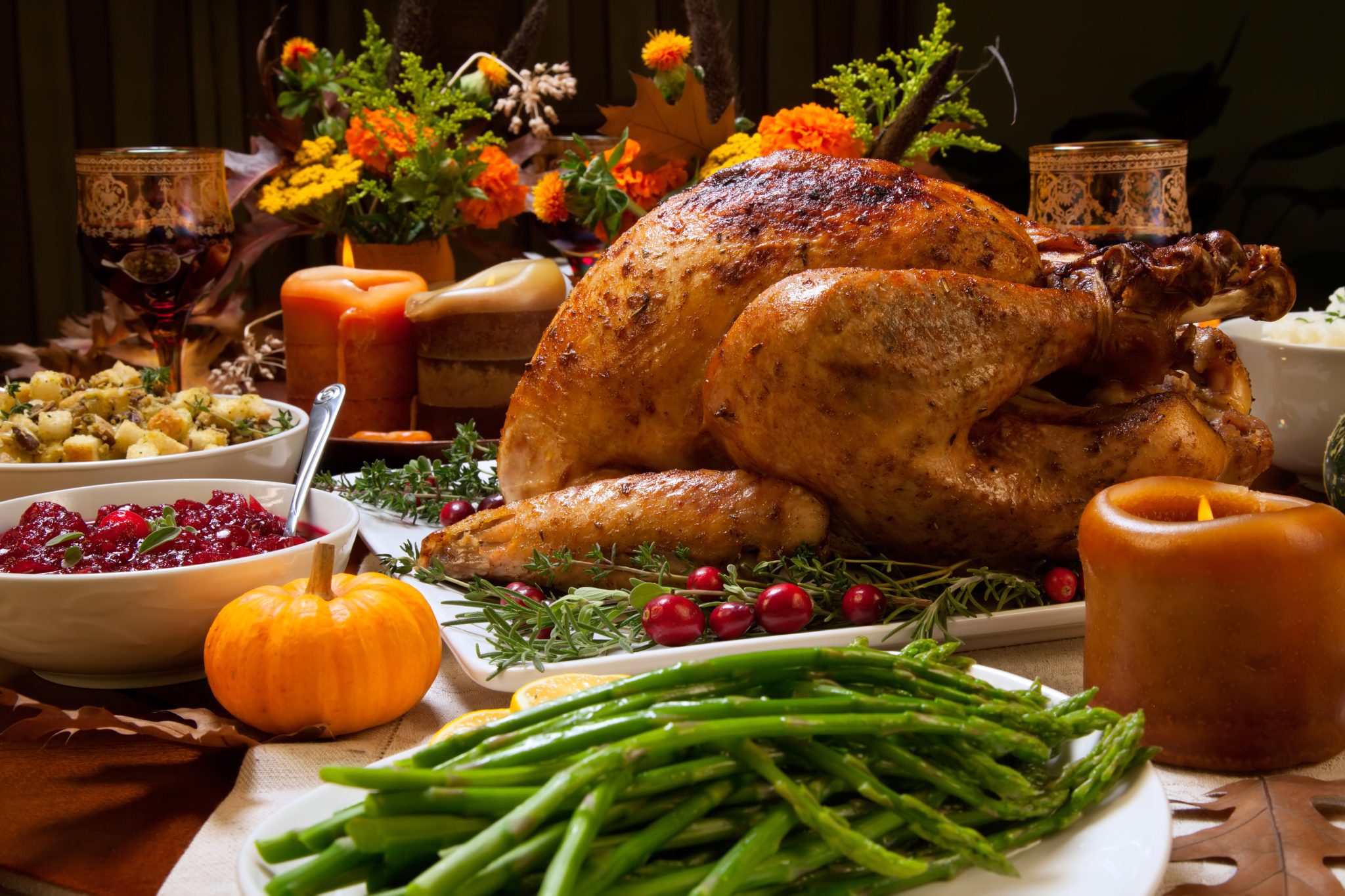 A Thanksgiving table of food with the turkey in the middle.