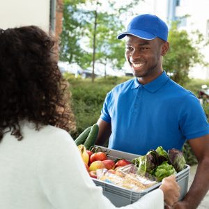 Smiling,Woman,Receiving,Grocery,Delivery,At,Home