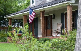 A house with an American flag hanging on the front porch