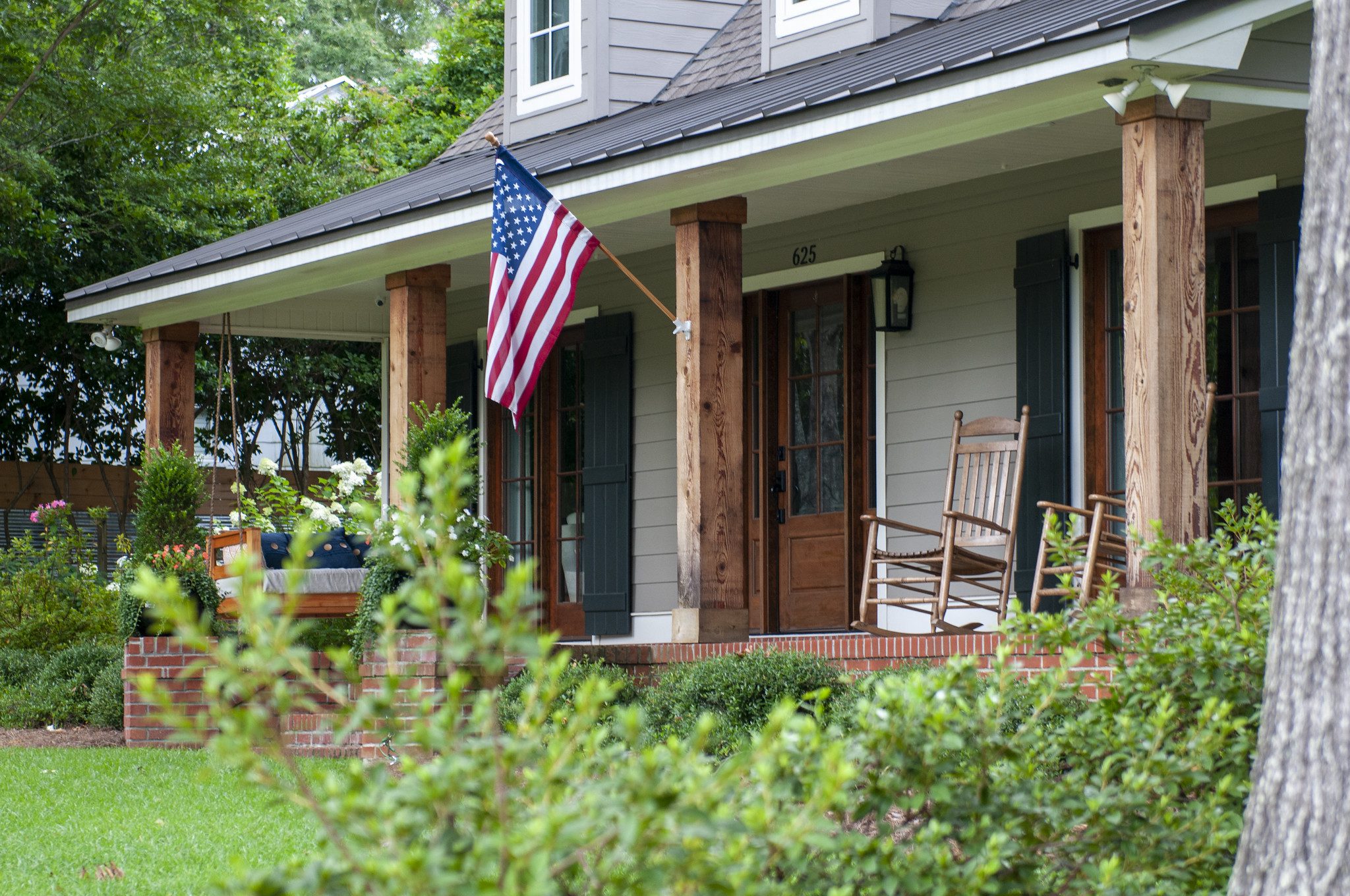 A house with an American flag hanging on the front porch