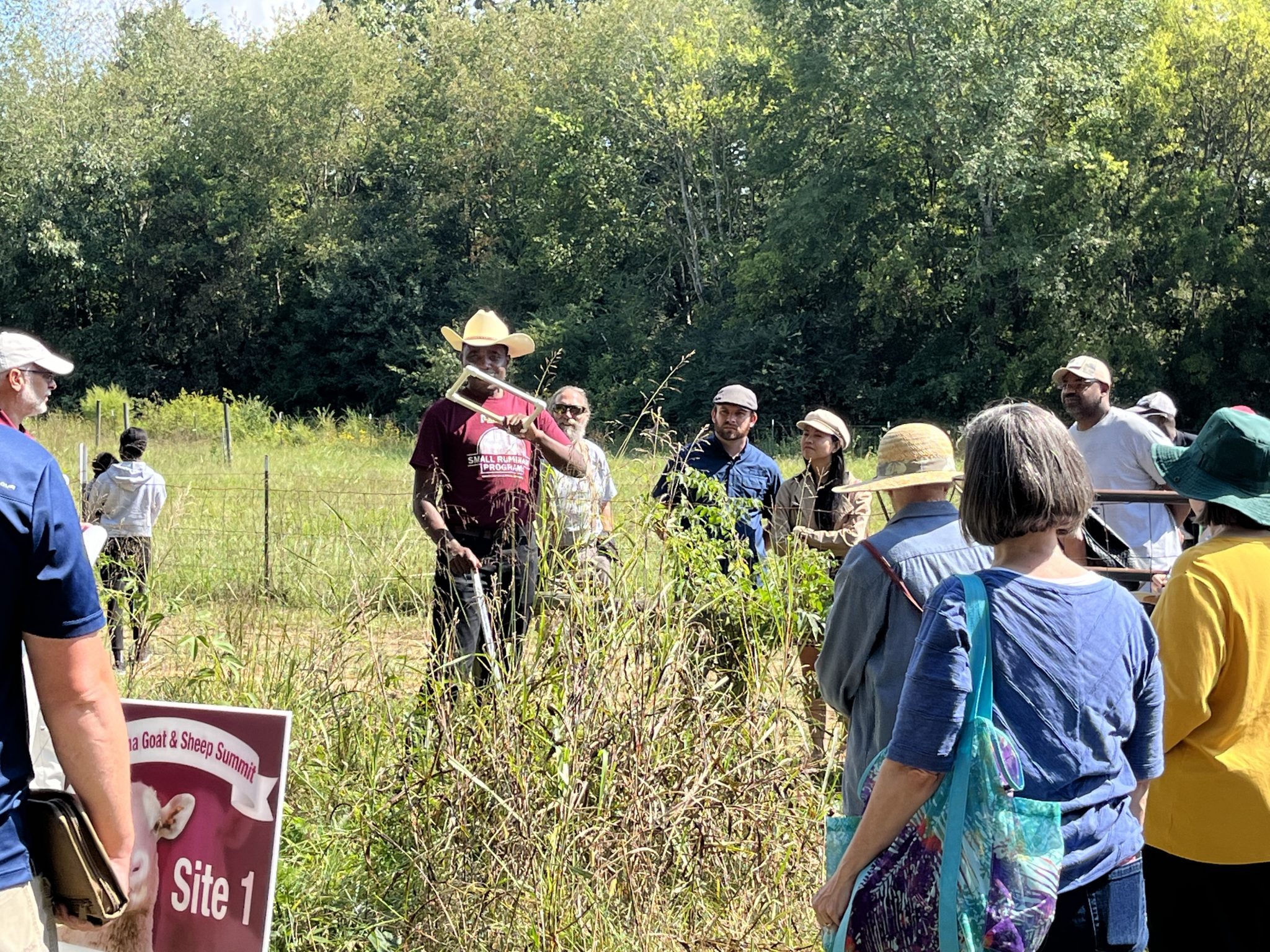 Specialist Valens Niyigena holds a field demonstration in a pasture for conference attendees.