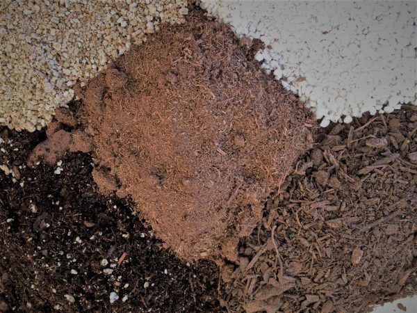 Figure 1. Components of a commercial potting mix. Vermiculite (upper right), perlite (upper left), peat moss (center). pine bark (lower right), and blended components (bottom left).