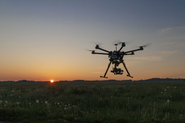 A drone flying across a sunset sky.