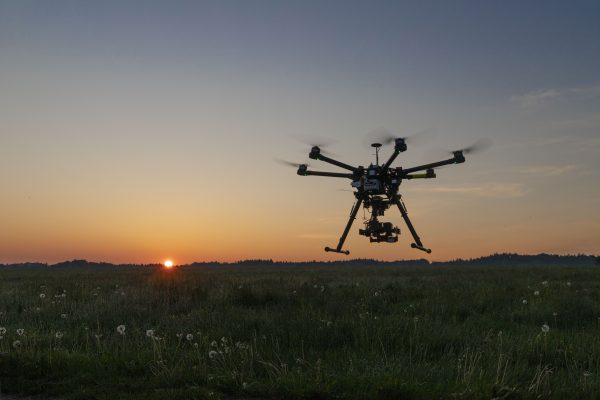 A drone flying across a sunset sky.
