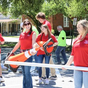 a group of students in red shirts move equipment for a roundabout