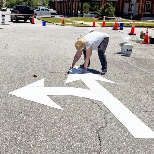 a woman lays down markings for a roundabout