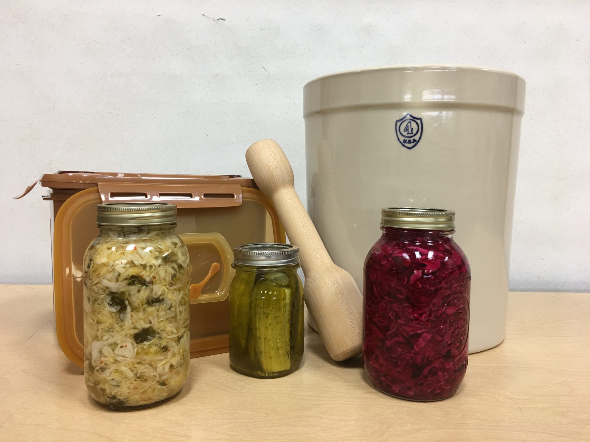 Tools used in fermentation with jars of fermented vegetables.