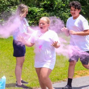 kids in white shirts sprayed with colored dust in color run