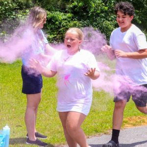 kids in white shirts sprayed with colored dust in color run