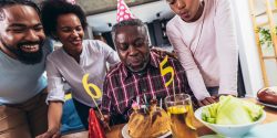 Multi-Generation african american family celebrating grandfathers birthday at home together