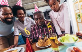 Multi-Generation african american family celebrating grandfathers birthday at home together