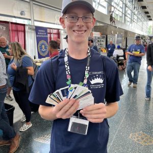 A 4-H member holding college business cards he got from a college fair.