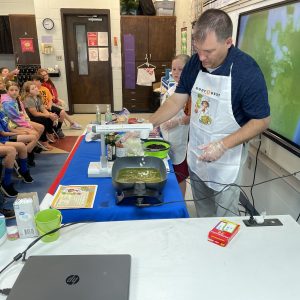man cooking in front of classroom