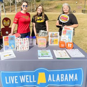 Three women, Move Alabama, flyers on table