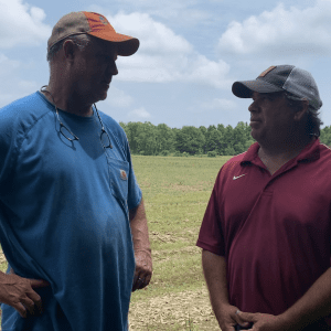Randall Beers and Kris Balkcom talk beside a peanut field being planted